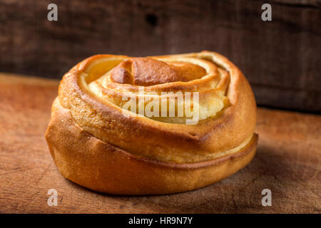 Lumaca dolce farcita con crema di dado su sfondo di legno Foto Stock