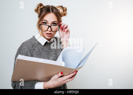 Bella giovane donna in bicchieri permanente e la holding legante con i documenti Foto Stock