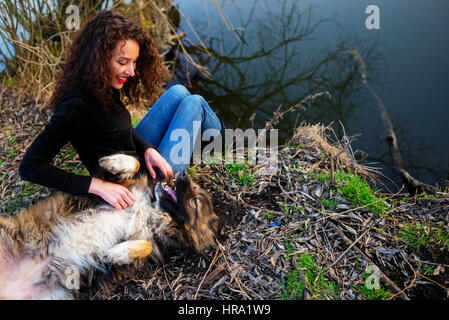 Giovane donna giocando con il Pastore del Caucaso in una piacevole giornata di primavera Foto Stock