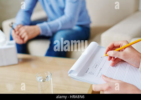 Processo di riempimento nella scheda sanitaria del paziente depresso in psicologi office, close-up shot Foto Stock
