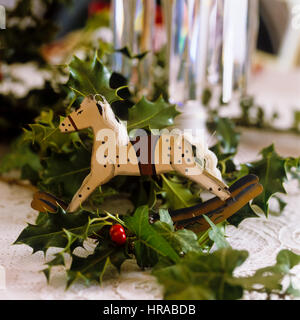 Un cavallo ornamento con holly. Foto Stock