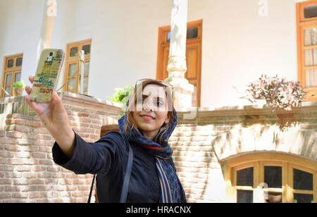 Giovani Medio Orientale donna sorridente prende selfie con lo smartphone in Iran Foto Stock