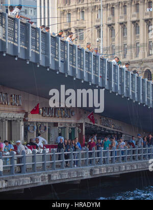 Persone di pesca mediante aste e la linea nel Corno d'oro, dal Ponte di Galata adiacente al Bosforo Istanbul TURCHIA Foto Stock