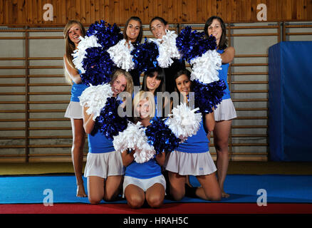 Giovane team di cheerleaders allenamenti in palestra Foto Stock