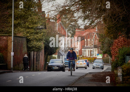 Un ciclista cicli Sandbatch down Road South in Alsager Village, Cheshire East, Inghilterra, Regno Unito. Foto Stock