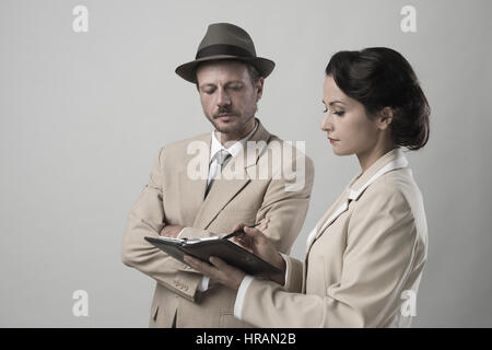 Vintage manager e segretario lavorando insieme controllare le note e gli appuntamenti Foto Stock