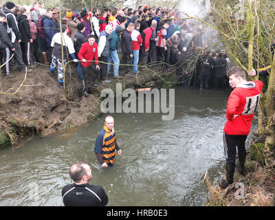 Ashbourne, Derbyshire, Regno Unito. Il rumble annuale tra il Uppards e Downards che è Ashbourne Royal Shrovetide Footabll luogo. Essenzialmente un gigante scrum di rugby che si svolge in tutta la città, i giocatori hanno per obiettivo la sfera in corrispondenza di uno dei due obiettivi e quale squadra si gioca per dipende dal fatto che vi sono nati verso l'alto o verso il basso del ruscello Henmore che greggi attraverso la città. Il tutto avviene di nuovo domani (1 marzo), il Mercoledì delle Ceneri. I giocatori nel ruscello Henmore. Foto Stock