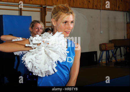 Giovane team di cheerleaders allenamenti in palestra Foto Stock