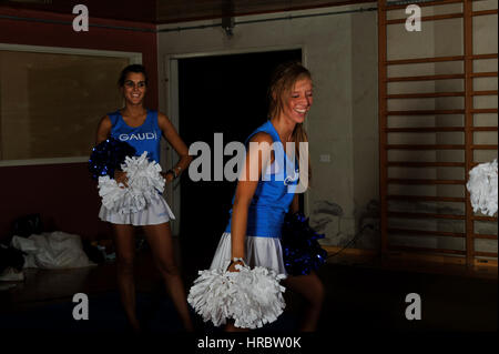 Giovane team di cheerleaders allenamenti in palestra Foto Stock