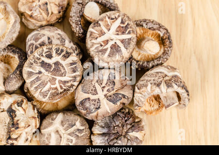 Essiccato funghi shiitake su sfondo di legno. Foto Stock