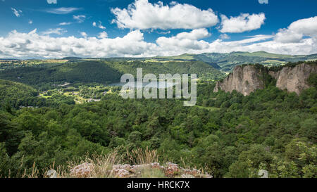 Scenic vista panoramica della campagna Auvergne in Francia con colline ricoperte da foreste, fiumi e un lago dominato da scogliere rocciose Foto Stock