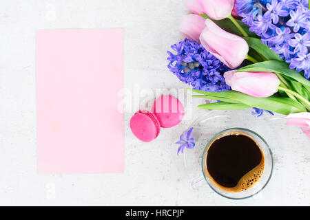 Tulipani rosa e blu giacinti fiori con tazza di caffè su bianco tavolo in legno con copia spazio su carta rosa card Foto Stock