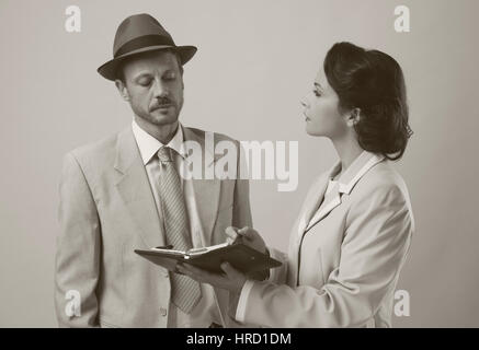 Vintage manager e segretario lavorando insieme controllare le note e gli appuntamenti Foto Stock