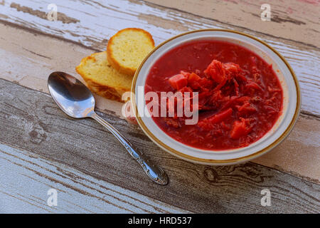 Borsch ucraino tradizionale zuppa di barbabietole rosse in vaso in ceramica su sfondo di legno Foto Stock