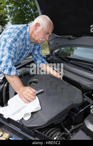 Uomo più anziano di pulizia motore auto con microfibra Foto Stock