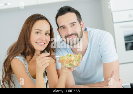 Giovane coppia felice avente insieme per la prima colazione con succhi di frutta e succhi di frutta Foto Stock