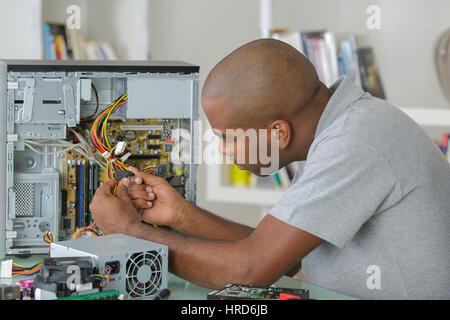 Computer repairman esaminando i cavi Foto Stock