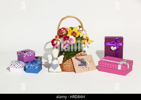Set di doni. Set dolce di fiori in cesto, diverse caselle, carta e artigianale di angelo su sfondo bianco. Foto Stock