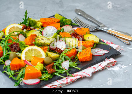 Cotto a vapore la patata dolce, broccoli e altre verdure su insalata di ardesia. Amore per un sano cibo vegan concept Foto Stock