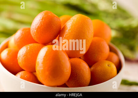 Primo piano di alcuni kumquat frutti in un bianco vaso in ceramica Foto Stock