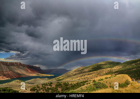 Questo paesaggio foto mostra un doppio arcobaleno contro un tempestoso cielo grigio sopra il Flaming Gorge National Recreation Area in Wyoming. Bear fiume è visto. Foto Stock