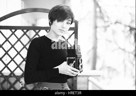 Roma, Italia. 26 febbraio 2017. Giovane donna graziosa posa con una Rolleiflex vintage, Telecamera in bianco e nero Foto Stock