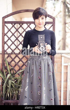 Roma, Italia. 26 febbraio 2017. Giovane donna graziosa posa sorridente con un vintage Rolleiflex fotocamera Foto Stock