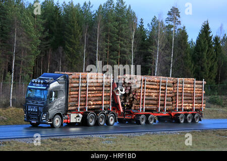 SALO, Finlandia - 5 dicembre 2016: Nero Volvo FH16 750 di M. Lehto Oy trasporta pino di pieno carico del registro lungo l autostrada bagnata all'inizio dell'inverno. Foto Stock