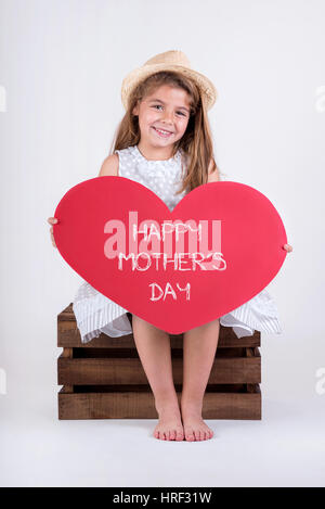 Felice Giorno della Madre. happy child ragazza ridere con cuore Foto Stock