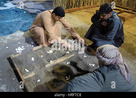 I partecipanti che interpretano il ruolo di un guscio gioco presso il Villaggio del Patrimonio Culturale, a Muscat Festival nel Parco Amerat, Oman Foto Stock