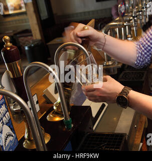 Barista tirando una pinta di birra, stacciature Doombar, in un pub. Foto Stock