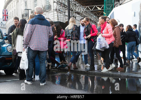 LONDON, Regno Unito - 22 Aprile 2016: persone bypassato una grande pozza vicino a Piccadilly Circus, cercando di attraversare la strada Foto Stock