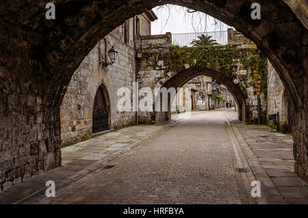 Torrette gotica, attraversata dalla parte inferiore da due grandi archi per dare modo al Camino Real de Cartes, Cantabria, SPAGNA Foto Stock