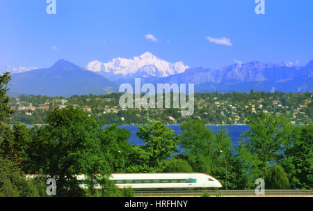 Il passaggio di un treno ad alta velocità sul lago di Ginevra e sulle Alpi Francesi con una vette del Monte Bianco nel centro. Foto Stock