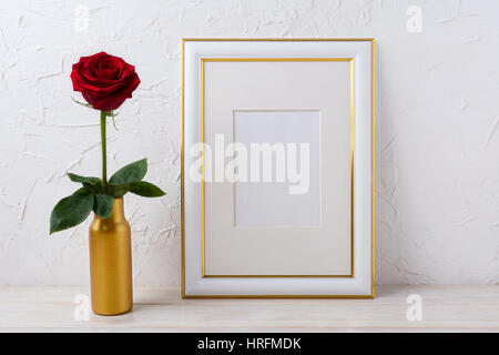 Telaio mockup con bordeaux red rose in vaso d'oro. Vuoto decorate in oro telaio mock up di presentazione di opere d'arte. Foto Stock