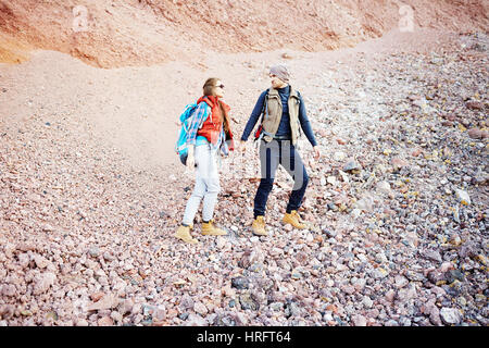 Ritratto di giovane turista giovane salendo Rocky Mountain percorso, ragazza ragazzo seguenti tenendo le mani sul escursione Foto Stock