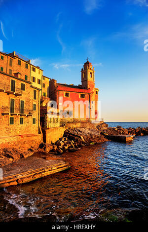 Tellaro rocce e vecchio villaggio sul mare. Chiesa e case sul tramonto. Cinque Terre, Cinque Terre Liguria Italia Europa. Foto Stock