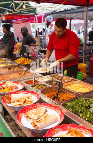 Un stallholder rendendo messicano cibo di strada in un cibo in stallo, Mercato di Portobello Road Portobello Road a Notting Hill, Londra UK Foto Stock