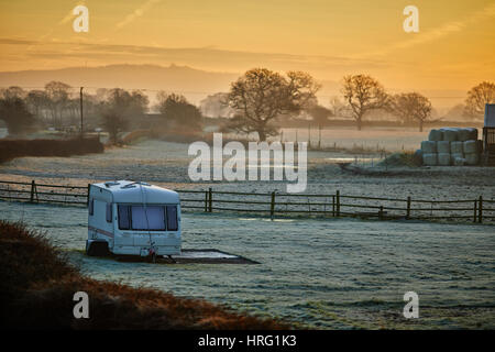 Una roulotte in un campo di agricoltori di tutto da solo all'alba, vicino a Stoke nel Cheshire, Inghilterra, Regno Unito. Foto Stock