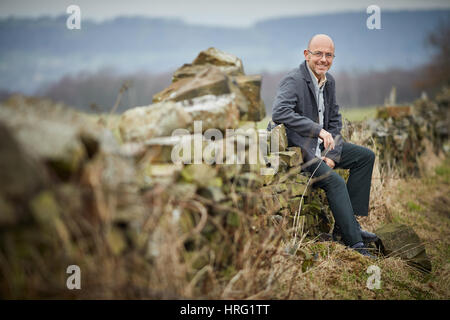 Hemingway proprietario di partenariato Wayne Hemingway in appoggio a secco su un muro di pietra nel rurale delle colline intorno a Blackburn, Lancashire, Inghilterra,UK. Foto Stock