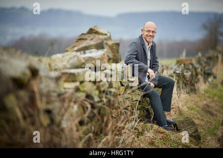 Hemingway proprietario di partenariato Wayne Hemingway in appoggio a secco su un muro di pietra nel rurale delle colline intorno a Blackburn, Lancashire, Inghilterra,UK. Foto Stock