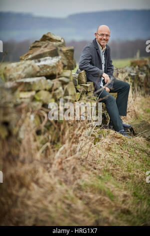 Hemingway proprietario di partenariato Wayne Hemingway in appoggio a secco su un muro di pietra nel rurale delle colline intorno a Blackburn, Lancashire, Inghilterra,UK. Foto Stock