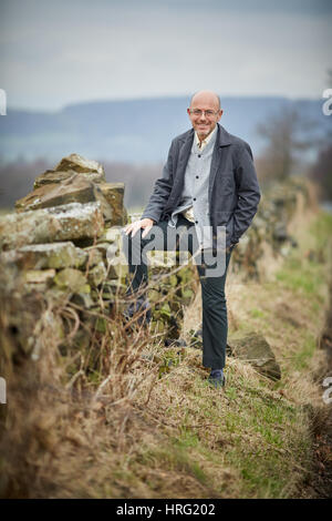 Hemingway proprietario di partenariato Wayne Hemingway in appoggio a secco su un muro di pietra nel rurale delle colline intorno a Blackburn, Lancashire, Inghilterra,UK. Foto Stock