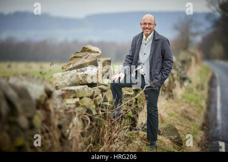 Hemingway proprietario di partenariato Wayne Hemingway in appoggio a secco su un muro di pietra nel rurale delle colline intorno a Blackburn, Lancashire, Inghilterra,UK. Foto Stock