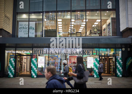 Esterno della Holland & Barrett più salute negozio apre nel centro della città di Manchester, Inghilterra, Regno Unito. Foto Stock