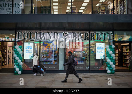 Esterno della Holland & Barrett più salute negozio apre nel centro della città di Manchester, Inghilterra, Regno Unito. Foto Stock