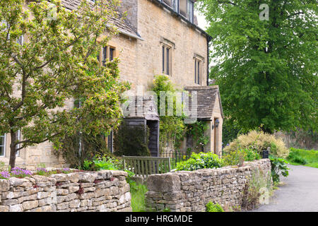 Tradizionale cottage inglese con giardini frontali racchiuso da un secco muro di pietra, da un sentiero, in un villaggio rurale . Foto Stock