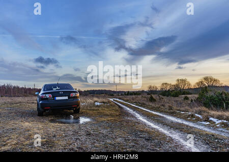 Nero auto sulla vecchia strada con le nuvole Foto Stock