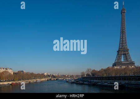La Torre Eiffel sorge maestosamente contro un cielo blu chiaro sulle rive del Fiume Senna, Parigi, Francia. Foto Stock