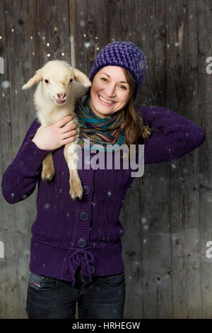 Frau mit Laemmchen bei Schneefall - donna con little lamb Foto Stock